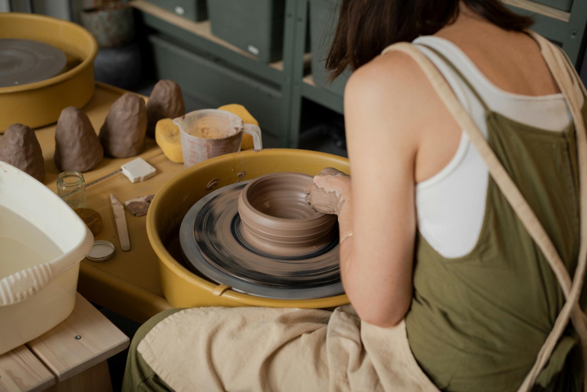 Potter shaping a clay bowl on a pottery wheel in a Berlin ceramics studio